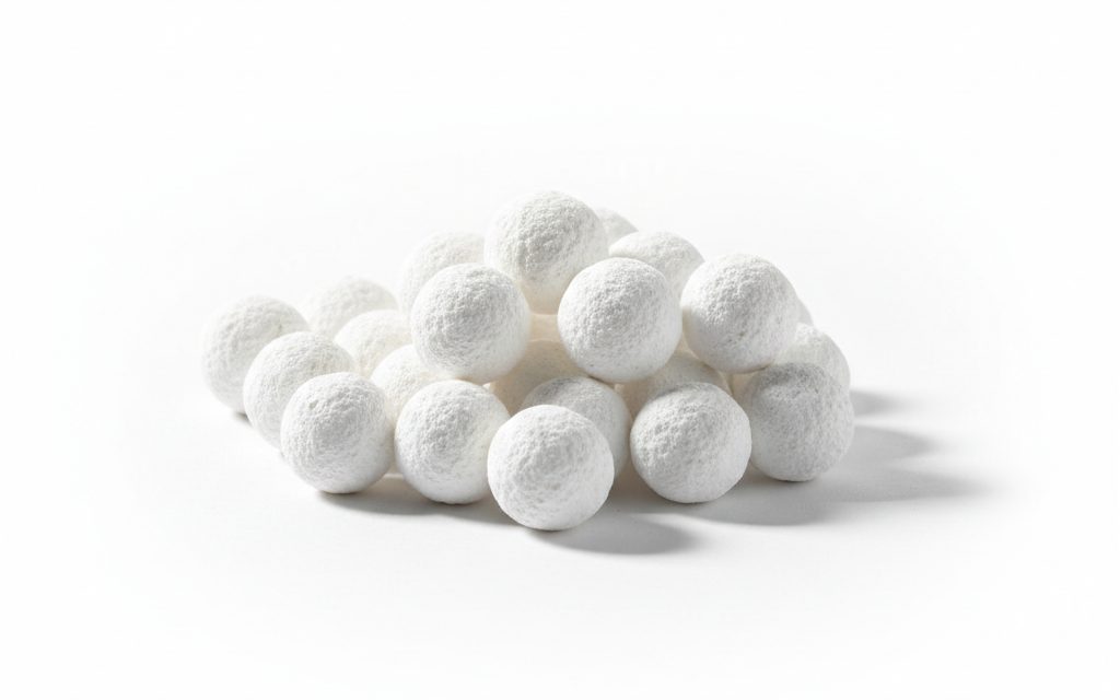 Activated Alumina — smooth, white spherical balls with a chalky, high-porosity surface that is dry to the touch and extremely hard, studio product photograph