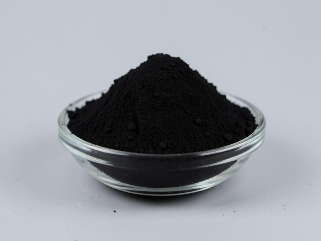 Activated Charcoal Powder (Coconut Shell) shown as a fine free-flowing powder in a shallow dish in a neutral studio photograph