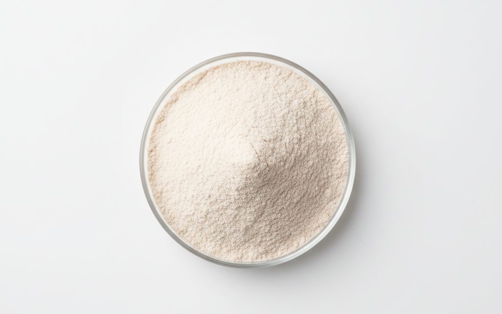 Alpha-Amylase — white to light brown powder or a liquid concentrate, often appearing as a fine, dry, flowable substance in a beaker, studio product photograph