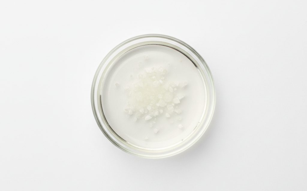 Grade confirmed at quotation — clear, colorless to pale yellow liquid or white crystalline powder; the solution is highly acidic and non-volatile, studio product photograph