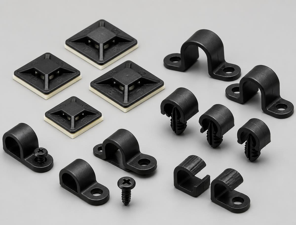Group of black nylon adhesive cable tie mounting bases, saddle clamps and push-in cable clips