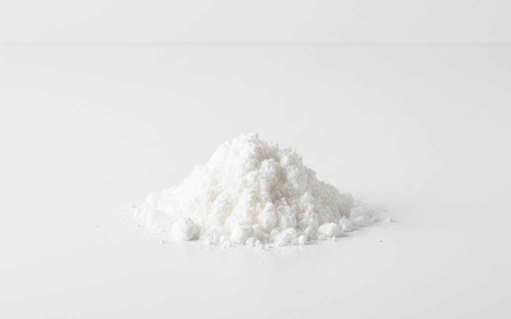 Grade confirmed at quotation — light, fluffy white powder with a faint acetic odor, characterized by very low bulk density and high hygroscopicity, studio product photograph