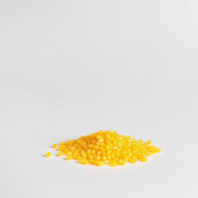 Vivid yellow colour masterbatch pellets shown as a neutral studio product photograph