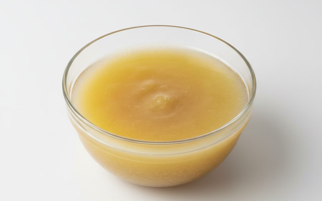 Grade confirmed at quotation — turbid, yellowish viscous liquid often exhibiting sedimentation at lower temperatures, becoming clear upon mild heating and agitation, studio product photograph