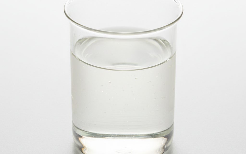 Grade confirmed at quotation — transparent, water-white to light yellow oily liquid featuring a low-foaming consistency and a clean, thin fluid texture, studio product photograph