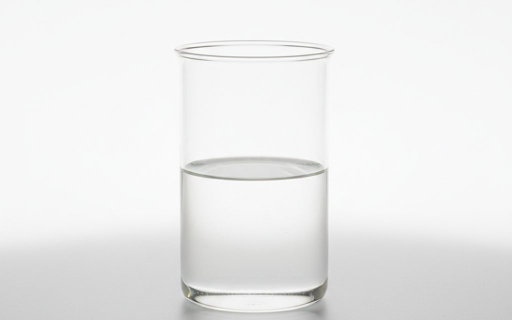Grade confirmed at quotation — clear to slightly hazy, colorless to pale yellow liquid with a thin water-like consistency and minimal chemical scent, studio product photograph