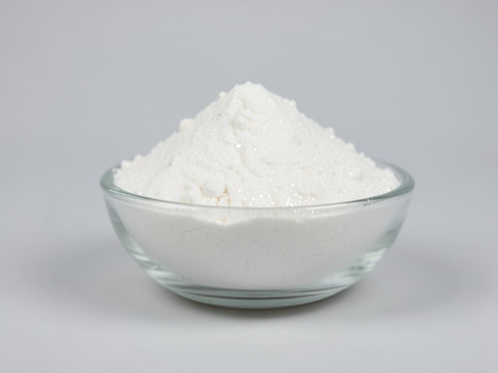 Glucosamine sulfate potassium chloride shown as a white crystalline powder heaped in a clear glass dish in a neutral studio photograph