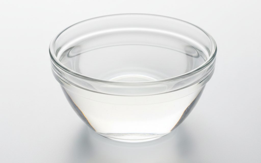 Grade confirmed at quotation — clear, colorless to pale yellow liquid with a sharp, pungent, and irritating odor; behaves like water in glassware, studio product photograph