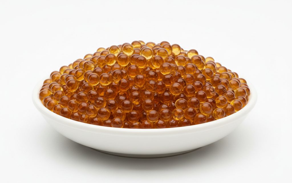 Ion Exchange Resin — small, uniform spherical beads ranging from translucent amber to golden-brown with a wet, slippery texture and glossy finish, studio product photograph