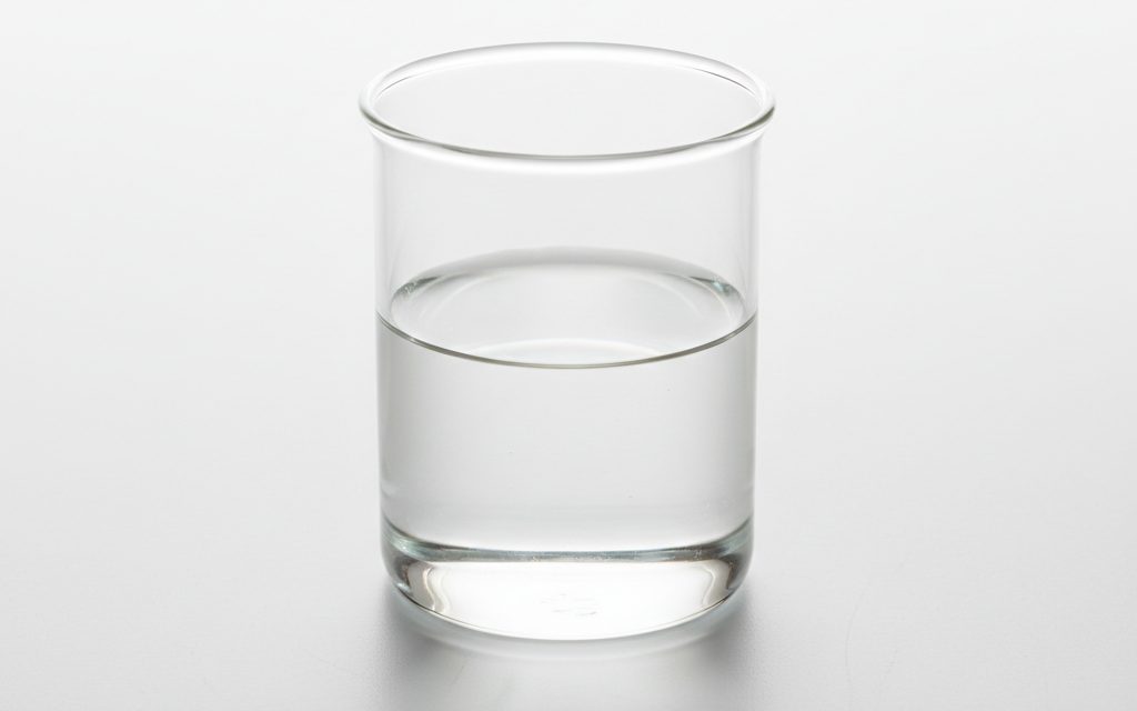 Grade confirmed at quotation — a clear, colorless, and mobile thin oily liquid with virtually no odor and excellent spreadability, studio product photograph
