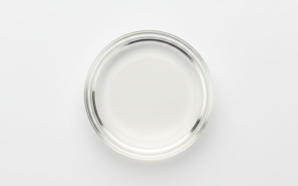 MCT Oil C8/C10 — colorless, completely transparent mobile liquid with a very thin, non-greasy mouthfeel and virtually no discernible odor or taste, studio product photograph