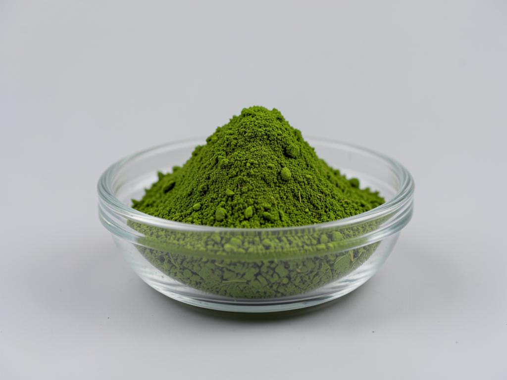 Moringa Leaf Powder shown as a dried milled botanical powder in a shallow dish in a neutral studio photograph