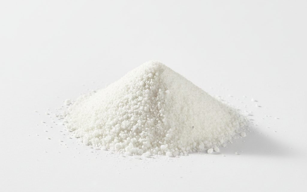 Niacin (Nicotinic Acid) — white crystalline powder or small white granules, appearing odorless and dry with a uniform, non-clumping texture, studio product photograph