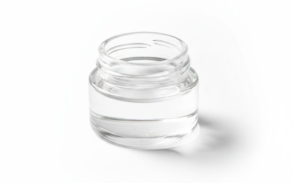 Grade confirmed at quotation — a clear, colorless, oily liquid with a faint rose-like scent and a high refractive index, studio product photograph
