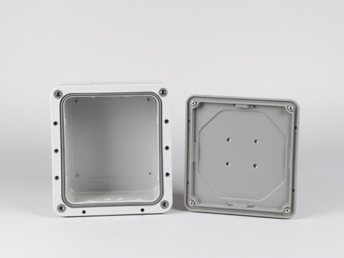 Plastic equipment enclosure with its lid removed alongside, showing the empty interior, perimeter gasket groove and internal mounting bosses