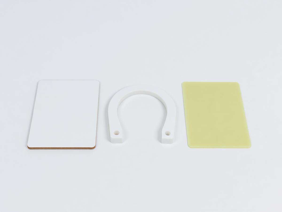Three plastic shim forms side by side — a plain flat rectangular packer, a horseshoe U-slotted shim and a thicker flat packing plate