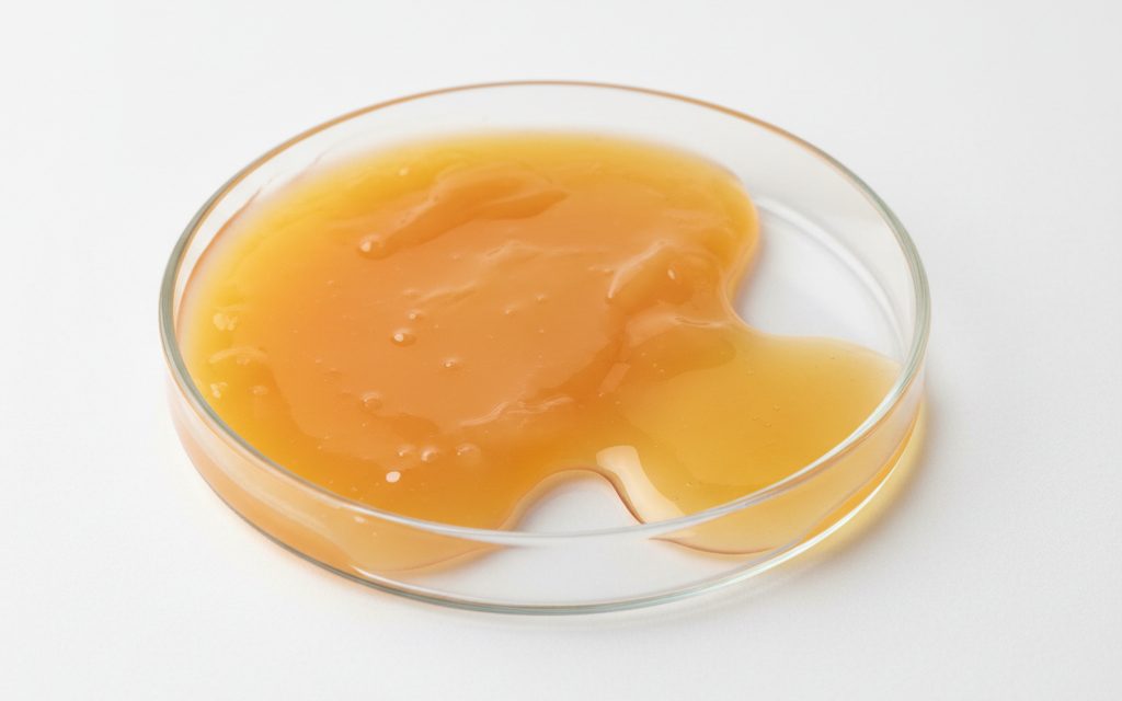 Grade confirmed at quotation — a thick, yellow to orange-yellow paste or semi-gel that transitions to a viscous liquid when slightly warmed, studio product photograph