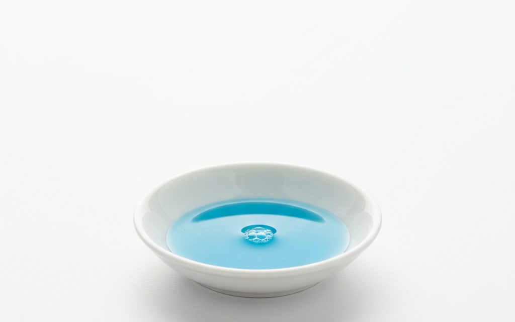 Grade confirmed at quotation — clear blue or green non-foaming liquid, typically featuring a slight soapy texture and mild chemical odor for microbial control, studio product photograph
