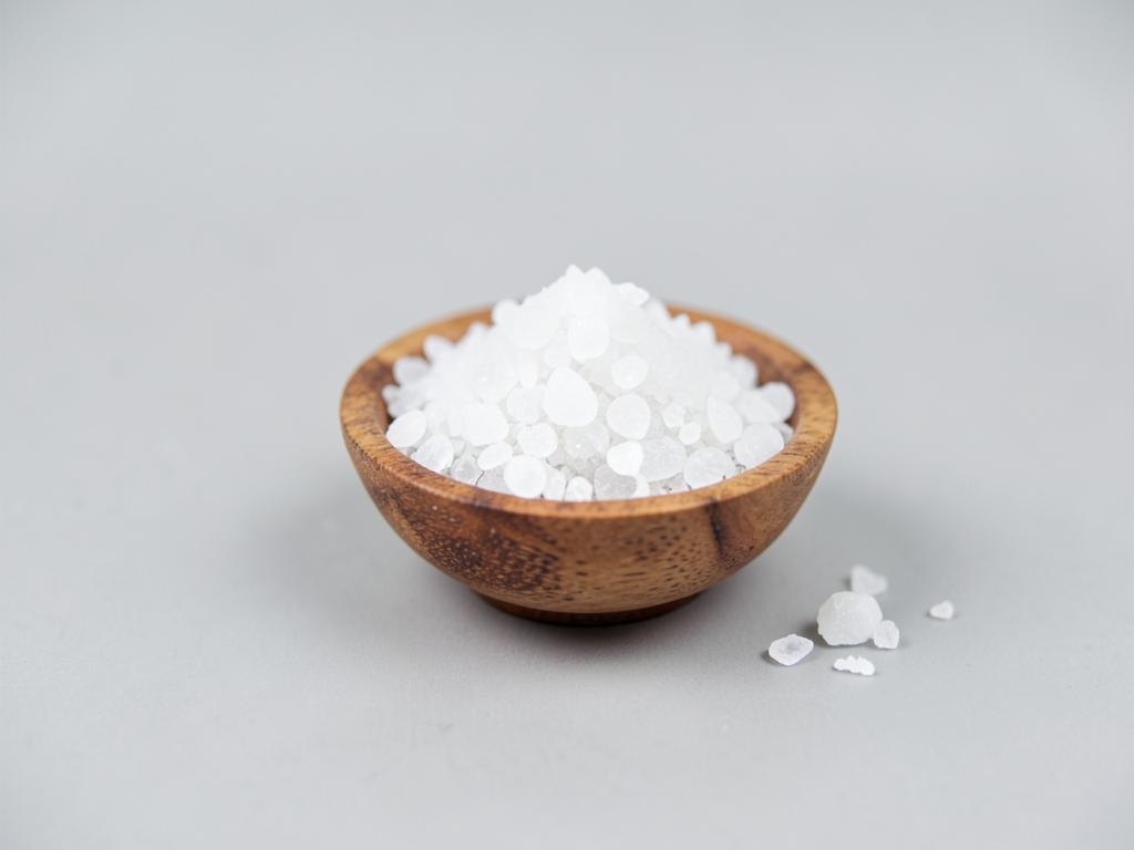 Food grade potassium chloride shown as fine white salt-like crystals in a neutral studio photograph