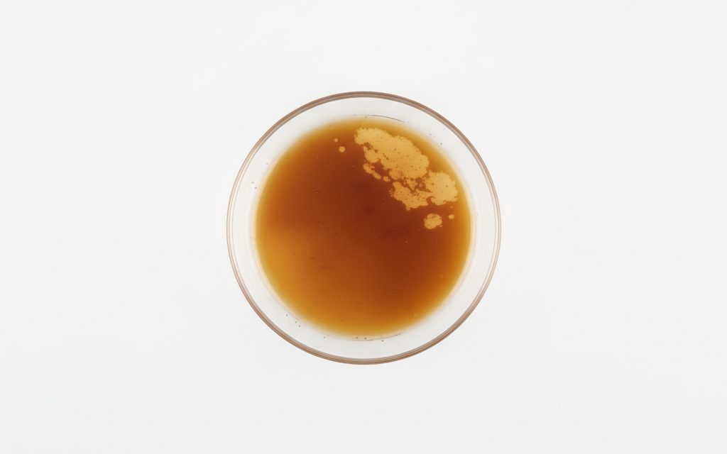 Grade confirmed at quotation — amber to dark brown waxy liquid or thin oily spray, providing a tacky, non-evaporating protective layer against atmospheric moisture, studio product photograph