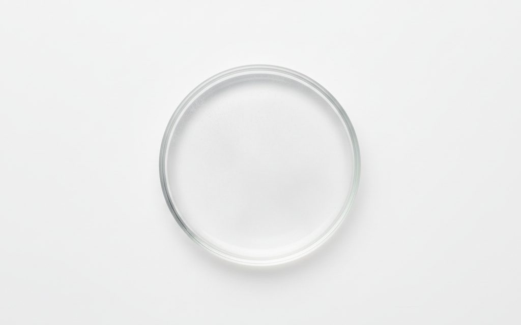 Grade confirmed at quotation — water-white, low-viscosity liquid lubricant delivered as a fine aerosol mist, creating a clear, friction-reducing, and water-repellent surface finish, studio product photograph