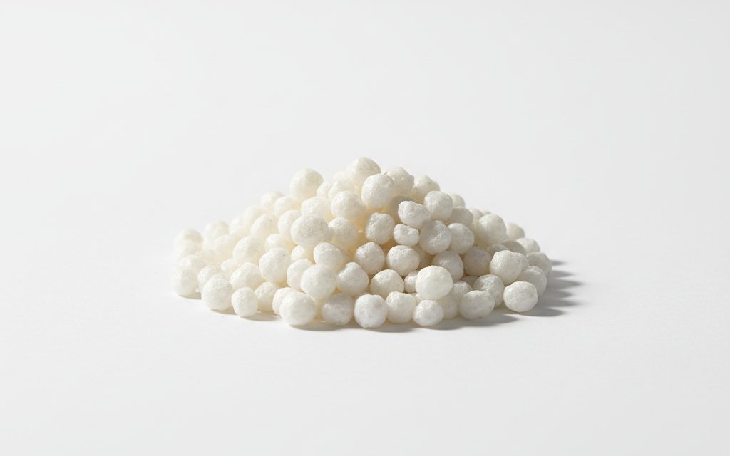 Sodium Butyrate / Coated Sodium Butyrate — white to off-white beads or granules with a protective lipid coating to reduce the pungent, characteristic odor of butyric acid, studio product photograph