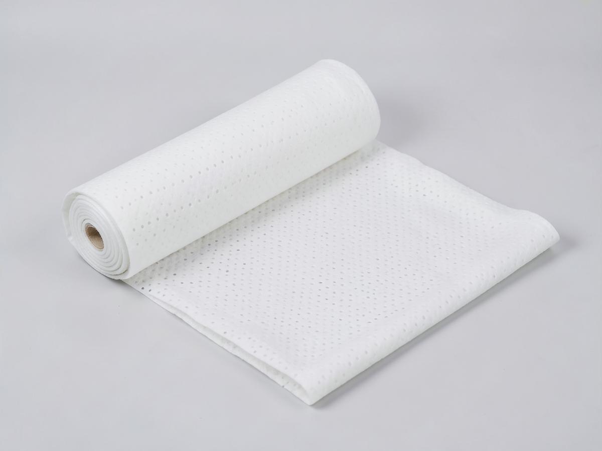 Soft white spunlace hydroentangled nonwoven fabric roll with an apertured perforated pattern