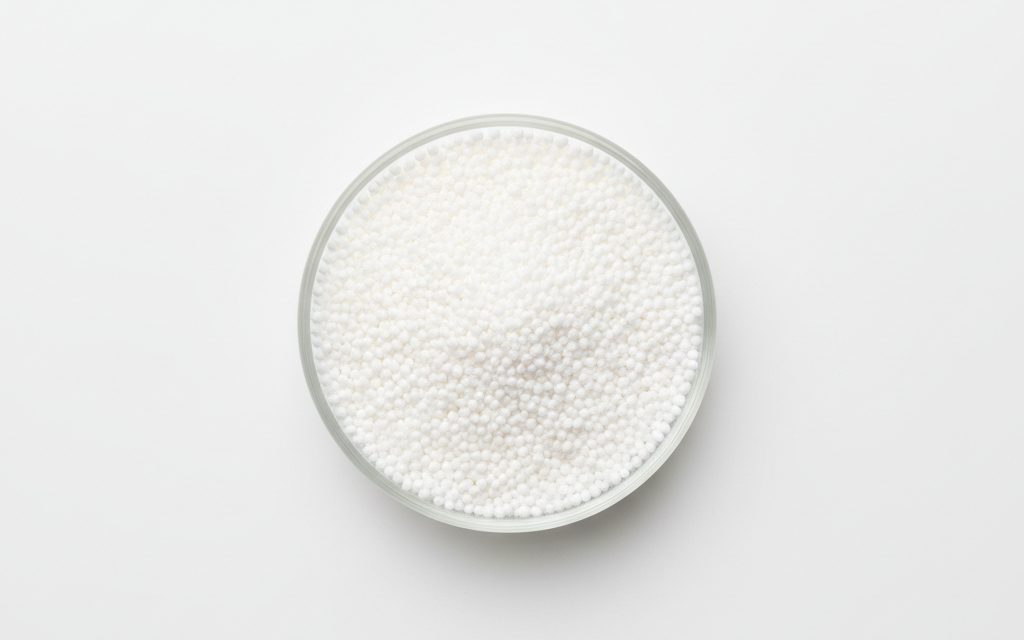 Grade confirmed at quotation — white, odorless, non-crystalline powder or spherical beads with a high-purity, uniform matte appearance in lab containers, studio product photograph